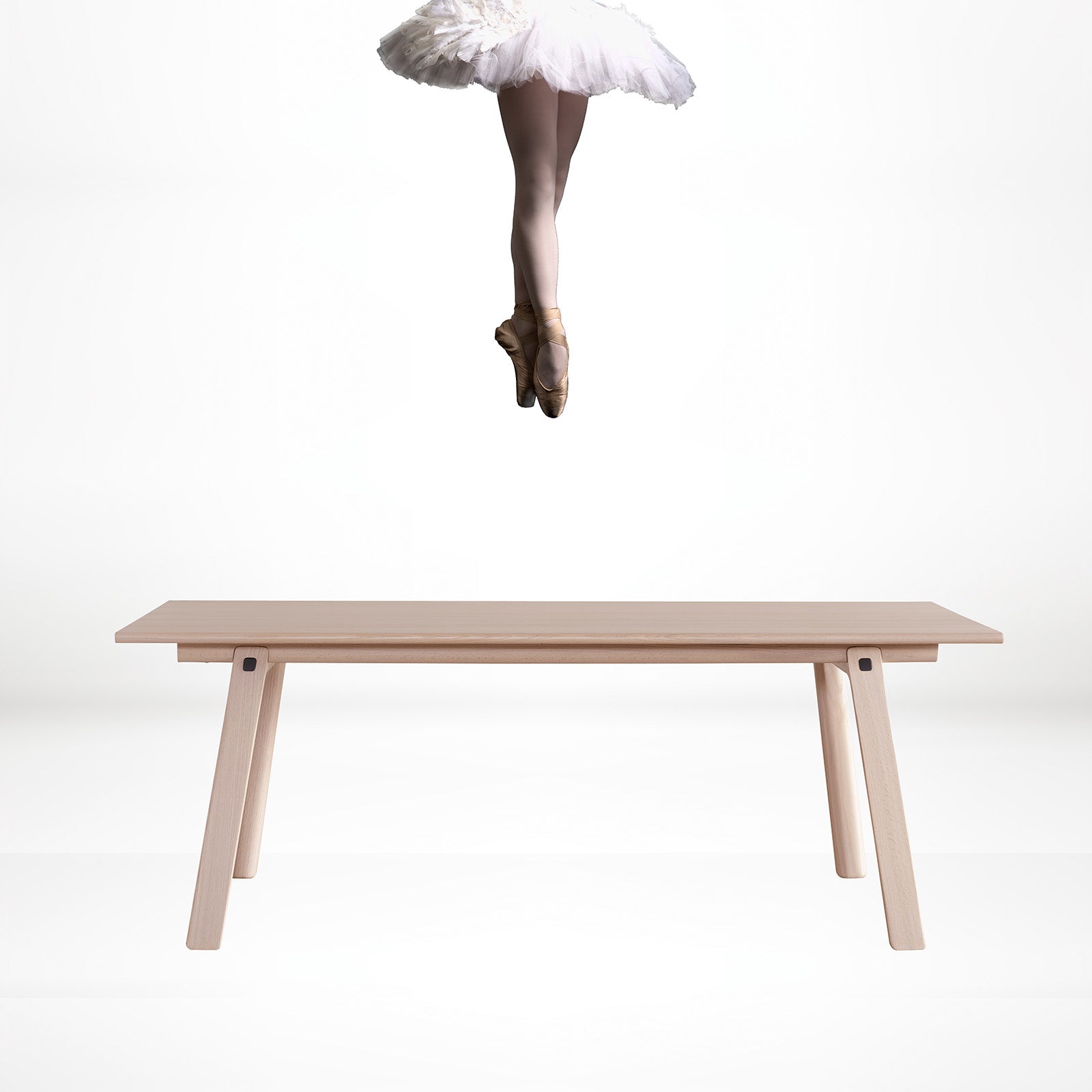 A graceful ballerina poised above the T&B table, showcasing its sturdy and elegant design.