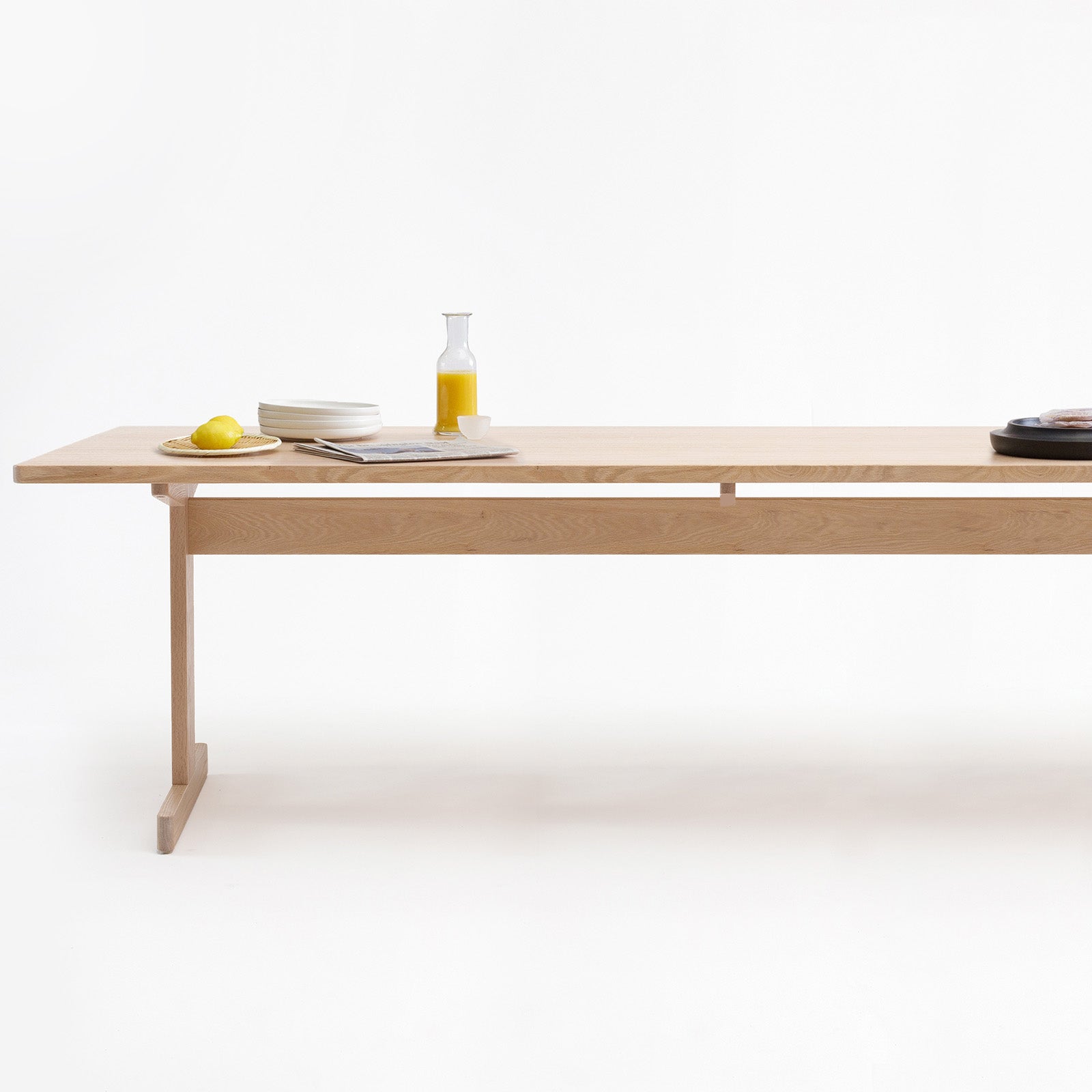 KufenKarl table in natural oak, elegantly styled with minimalistic tableware. A sustainable and functional centerpiece for dining and workspaces.