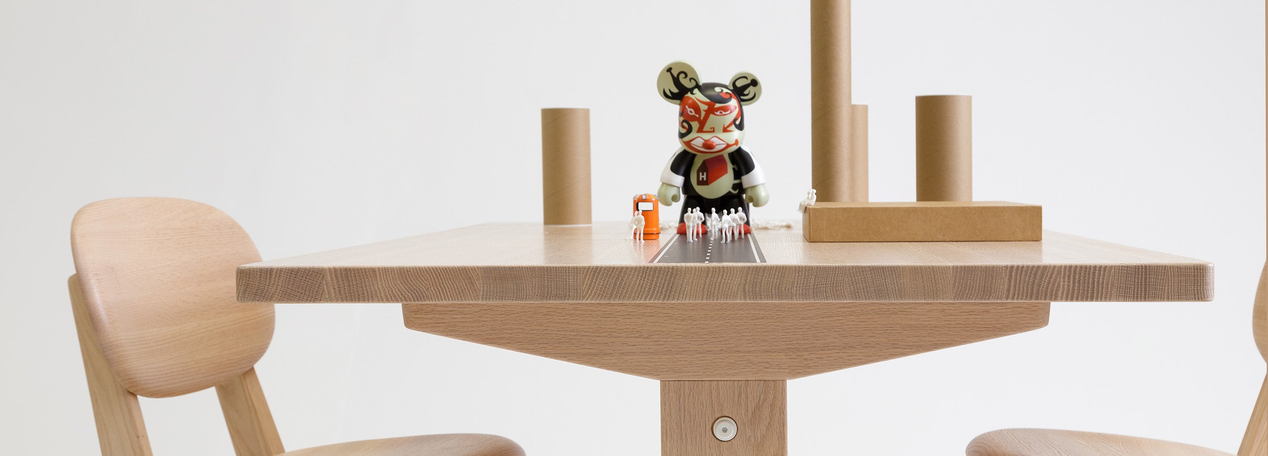 Close-up of KufenKarl’s oak tabletop showcasing fine craftsmanship, accompanied by playful miniature figures