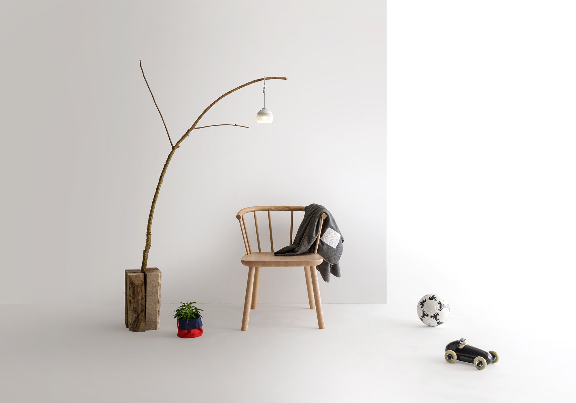 Studio Lounge Chair styled in a minimal setting, featuring a branch lamp and neutral decor, showcasing its versatility in modern interiors.