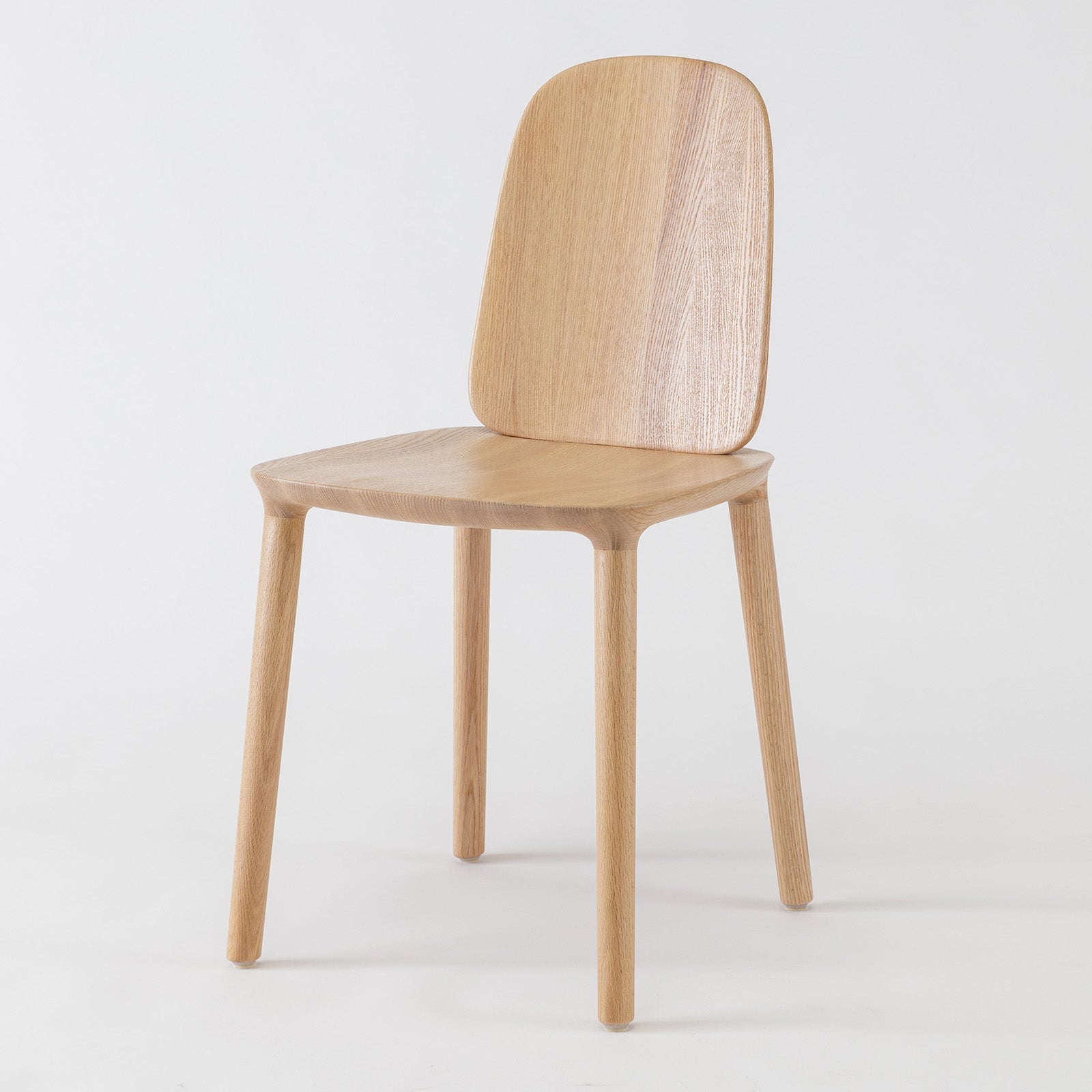 Side view of Kokoro Lounge Chair in oak, natrural finish, highlighting its sculptural form and relaxed silhouette.