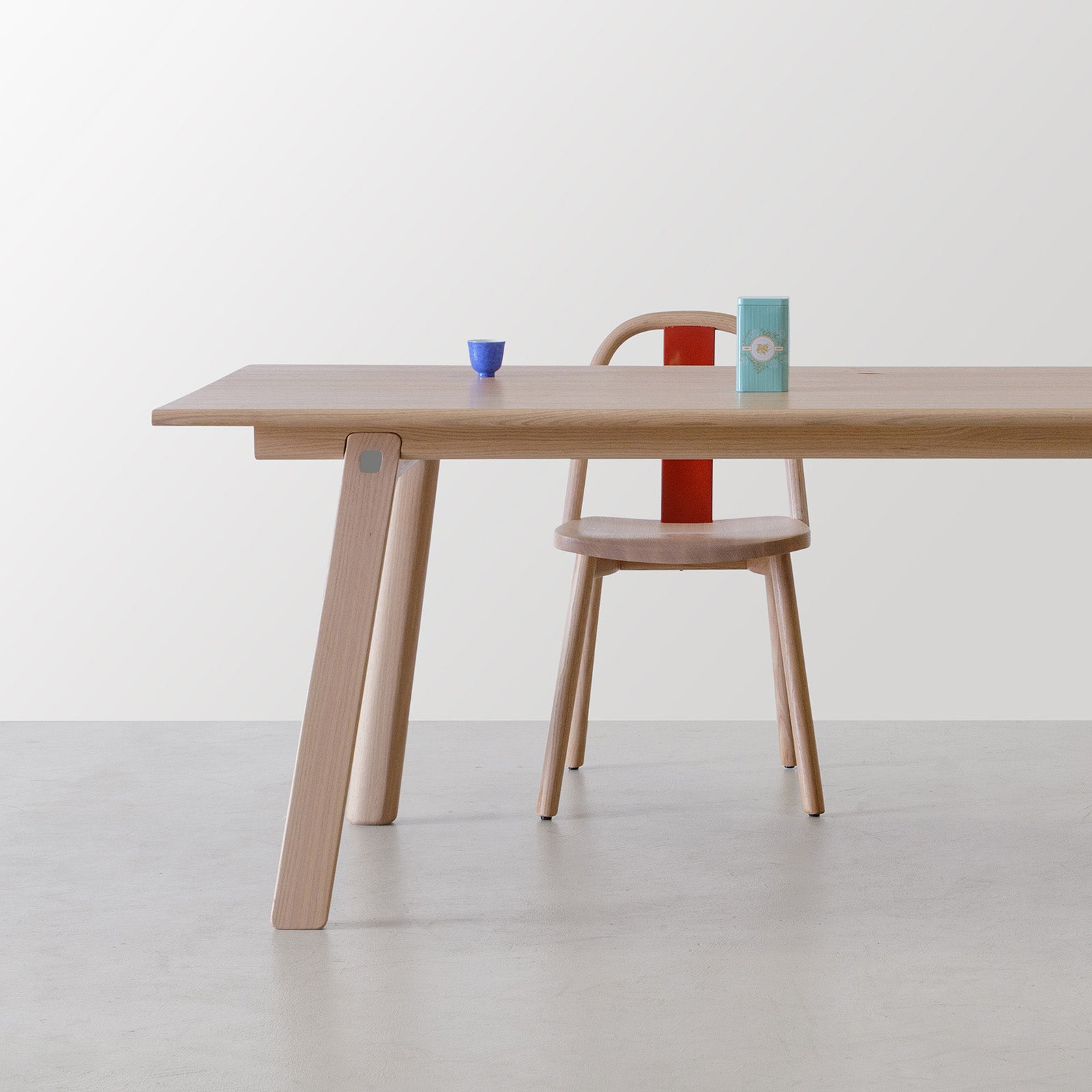 Chin-Chin chair in natural oak with a red lacquered backrest paired with T&B oak dining table, styled with minimal tea accessories.