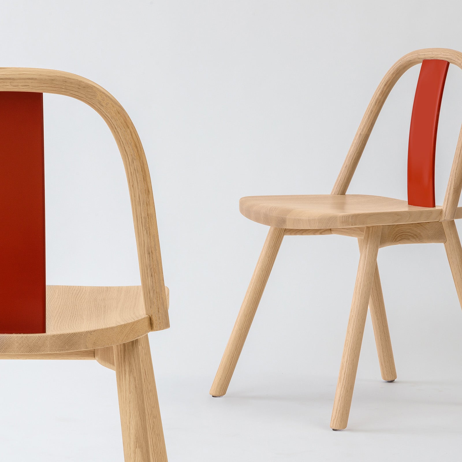 Chin-Chin chair in oak with a glossy red lacquered backrest, reflecting its vibrant homage to traditional Chinese design.