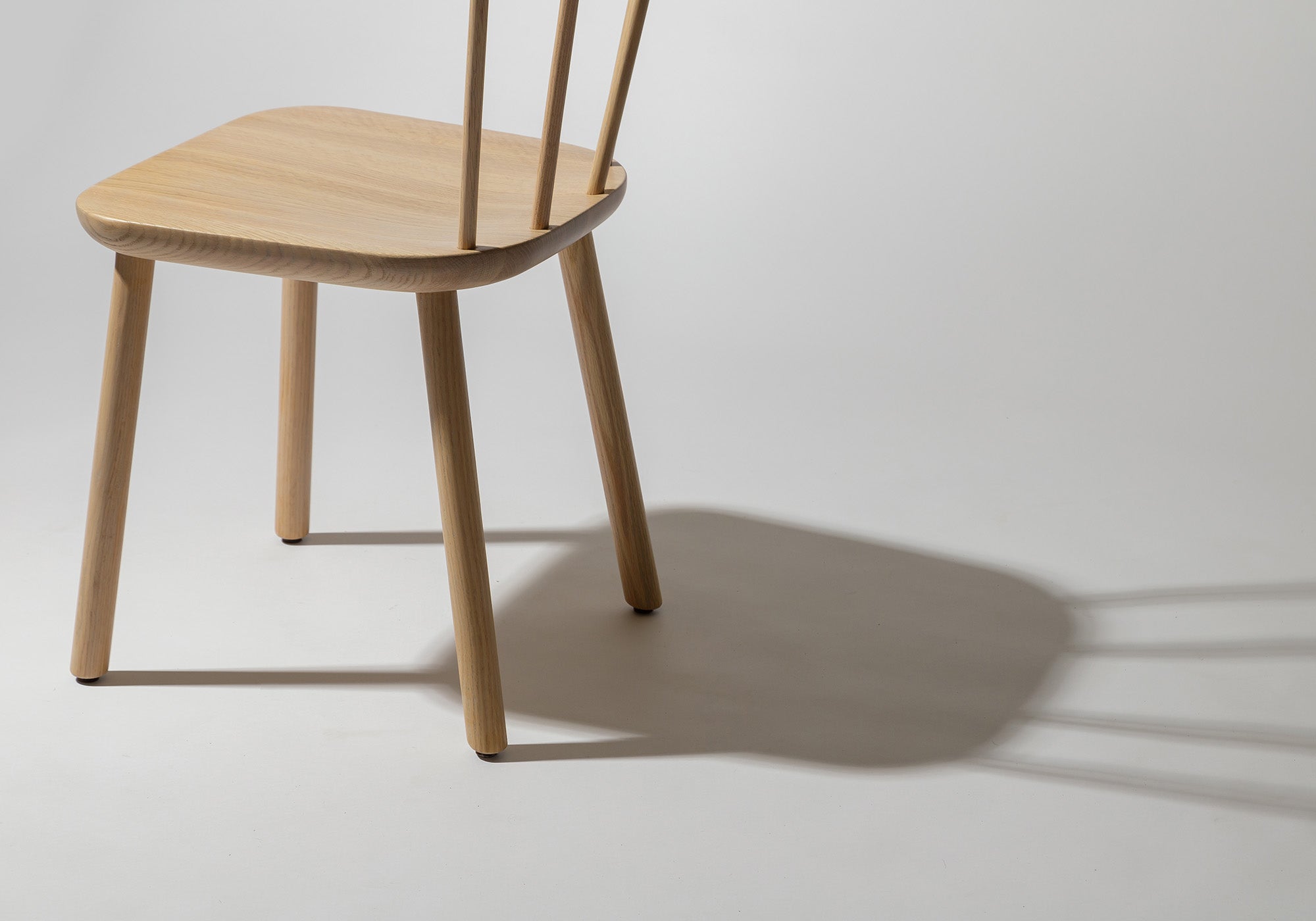 Partial view of the Studio Chair, highlighting its minimalist design and oak craftsmanship.