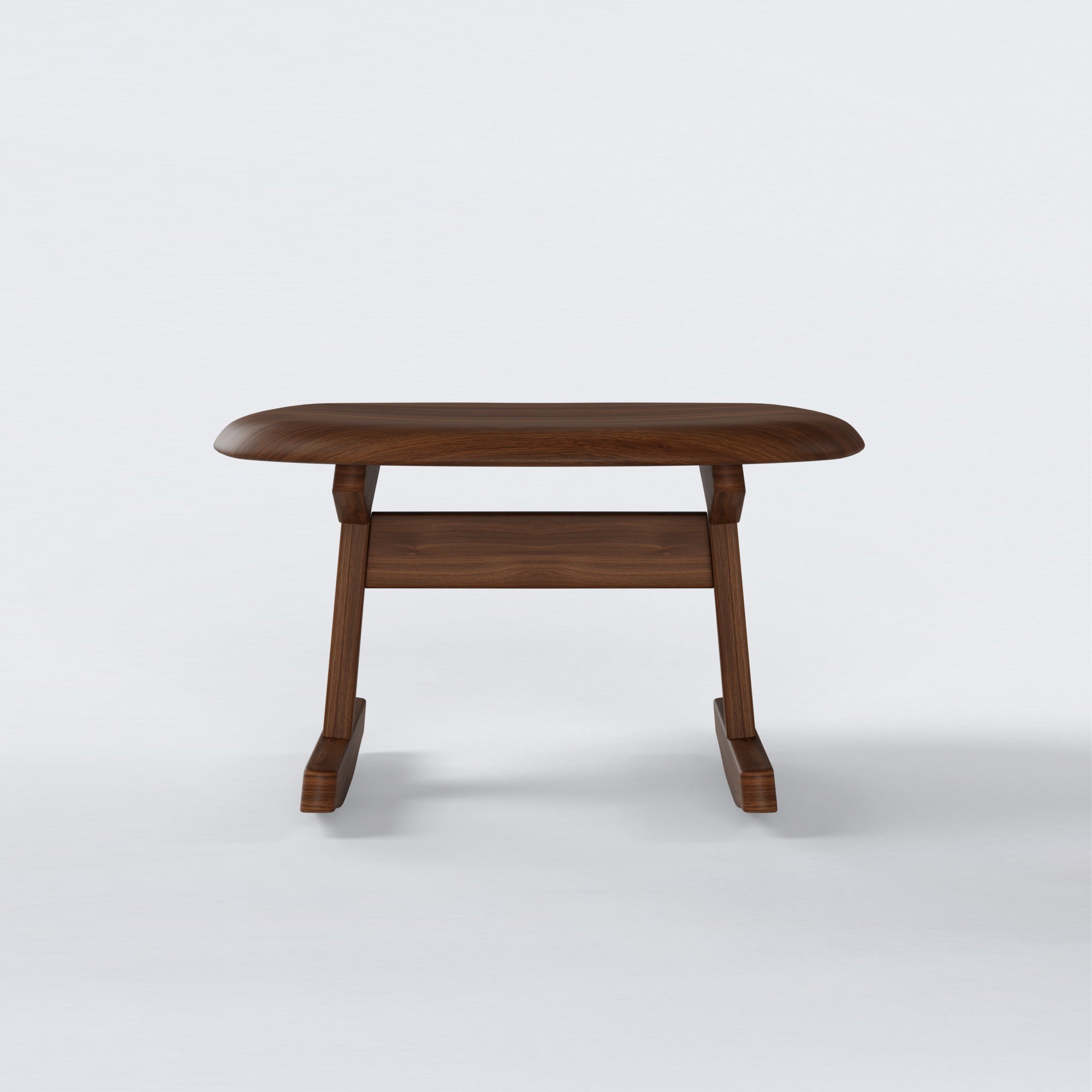 KufenKarl Rocking Ottoman in walnut – front view, showcasing its curved seat and smooth rocking base.