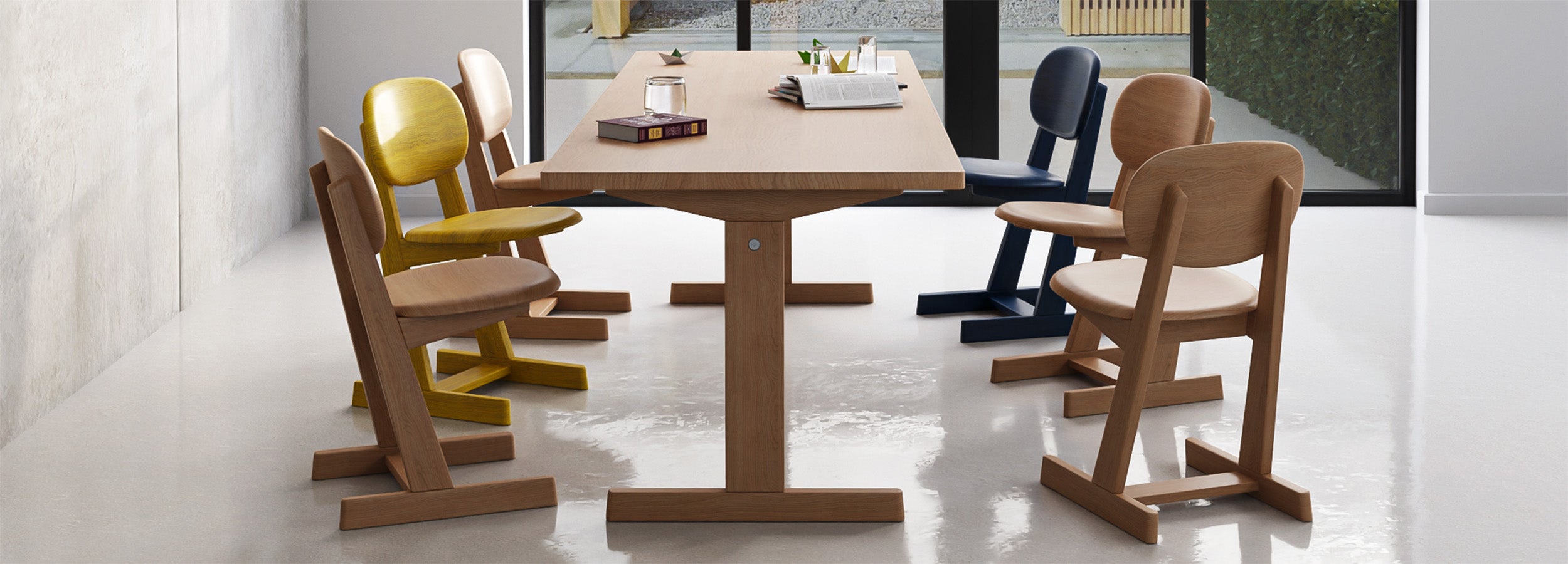 KufenKarl dining table paired with colorful KufenKarl chairs in a contemporary setting. Crafted from solid oak, designed for durability and modern versatility.