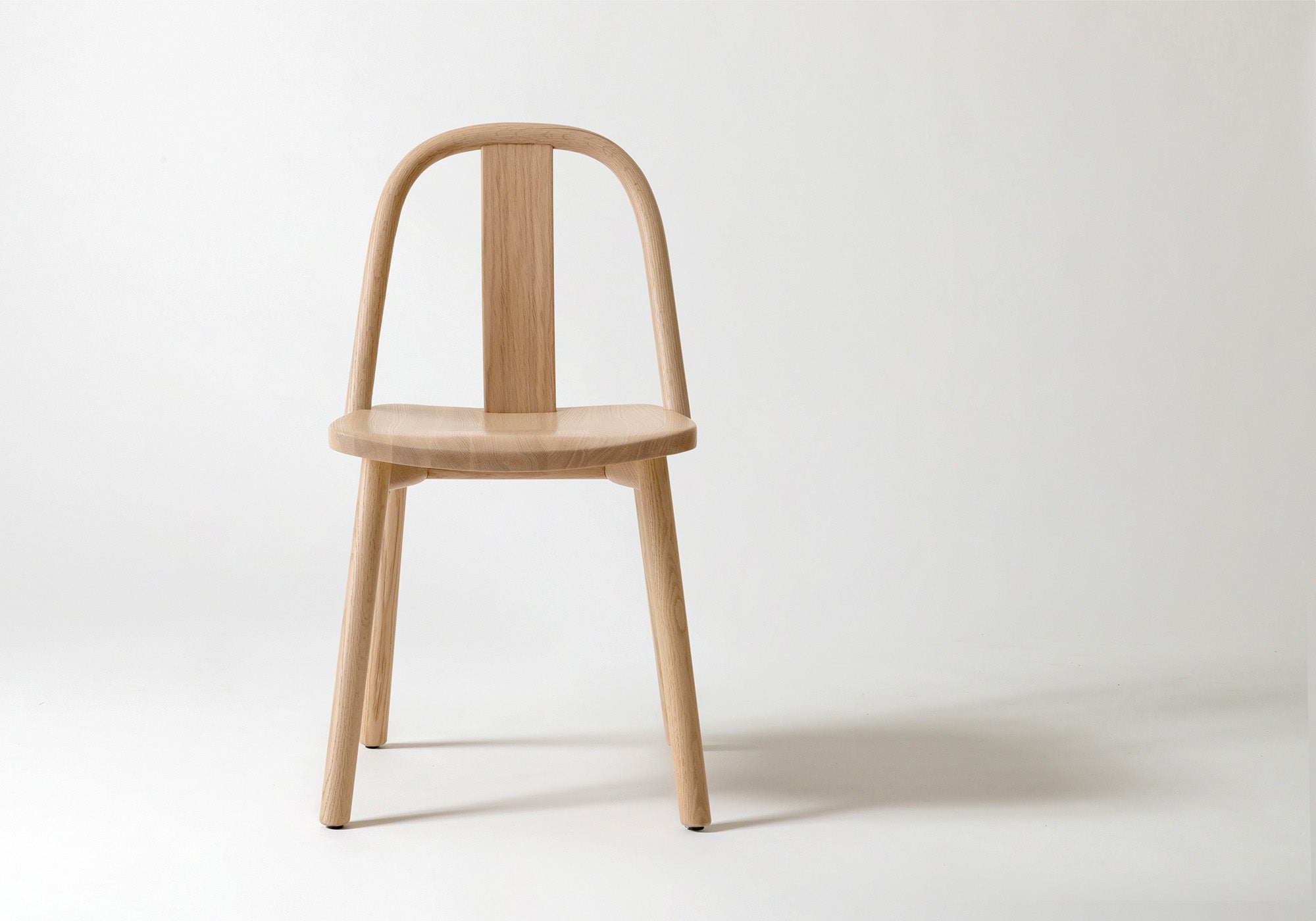 A single Chin-Chin chair in natural oak, showcasing its slender backrest and minimalist design inspired by traditional Chinese aesthetics.