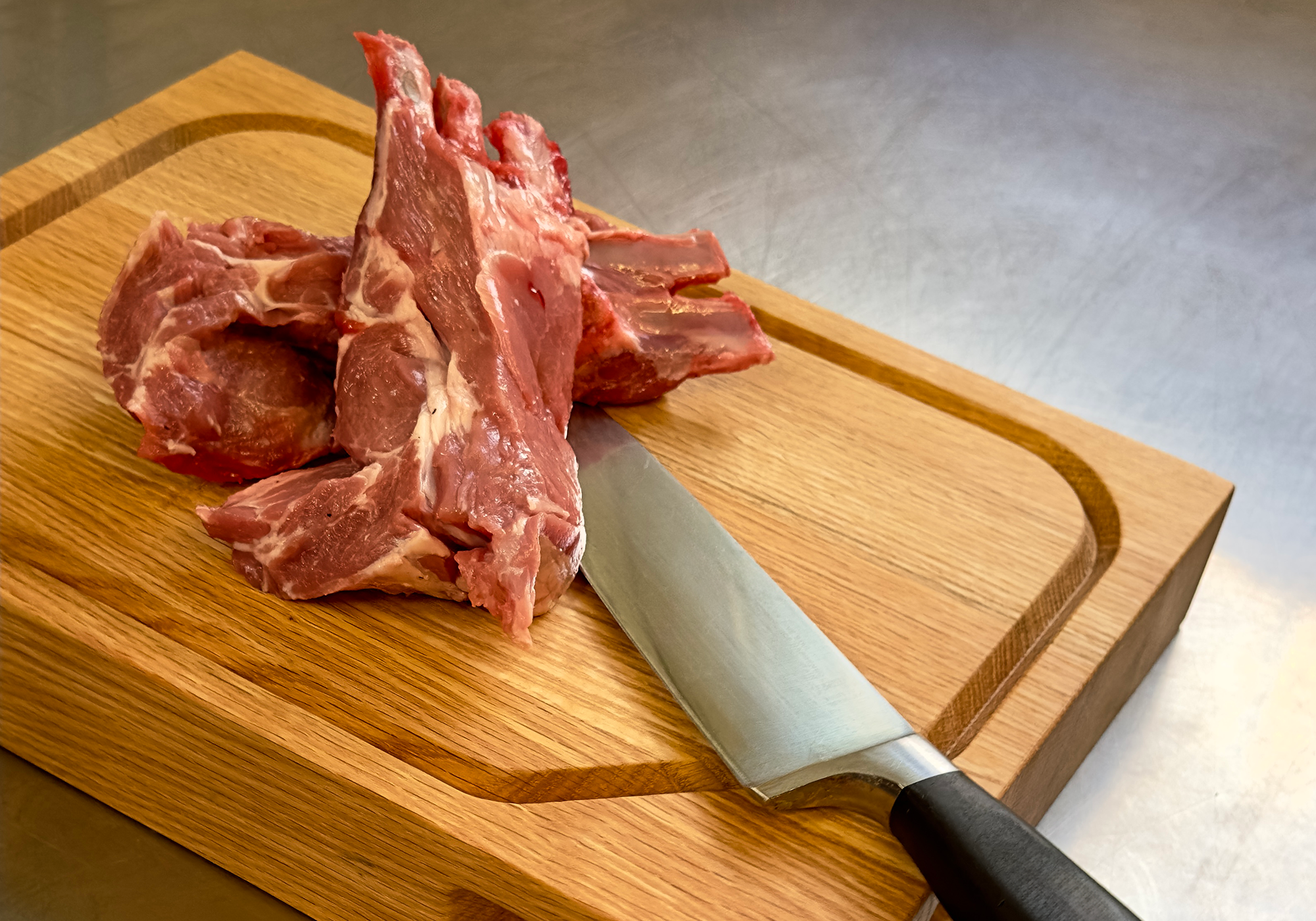BO_ cutting board with a knife and raw meat, exemplifying practical use.