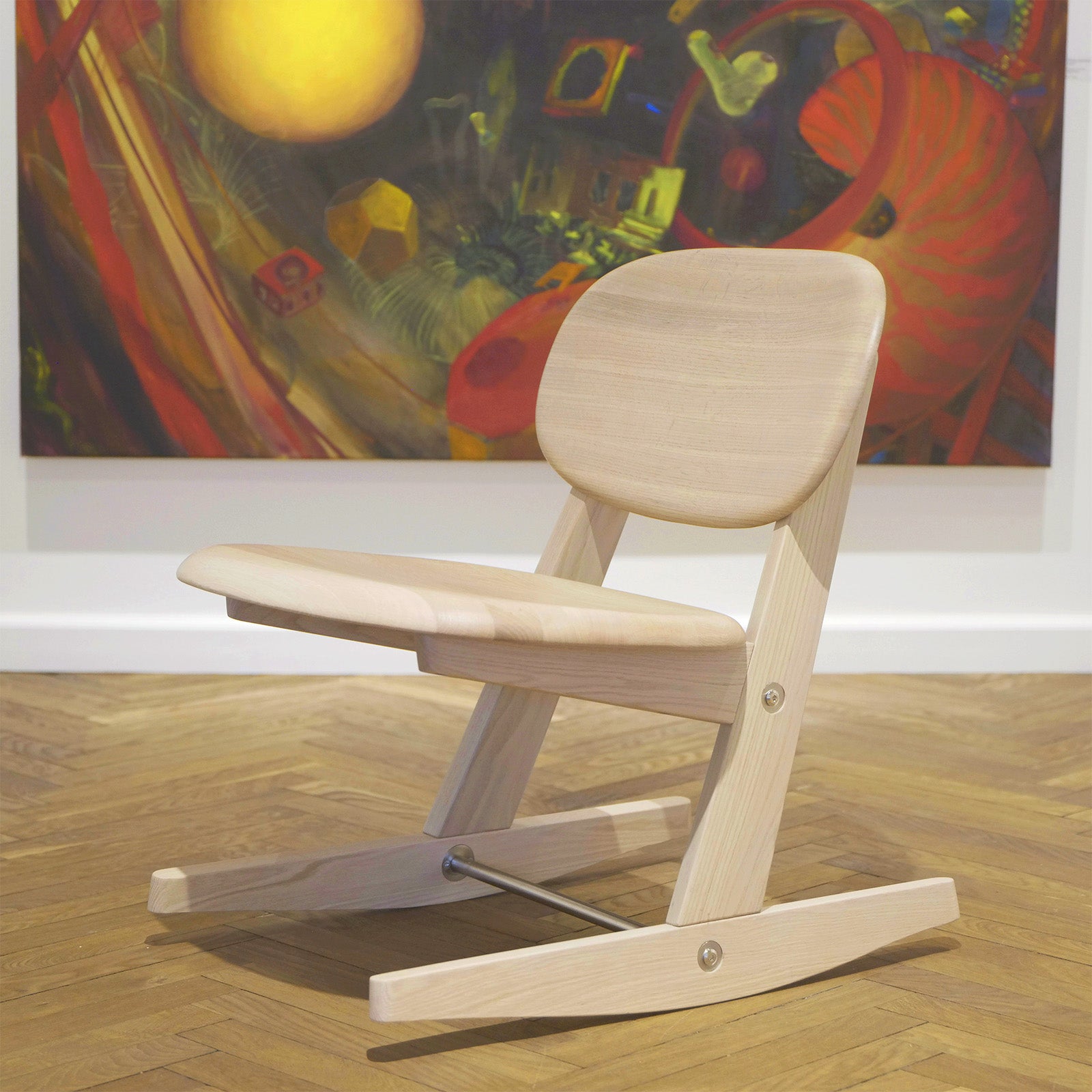 KufenKarl lounge chair in natural oak, showcasing its ergonomic design and seamless joinery. Set against an artistic backdrop @ Galleri MollerWitt, CPH