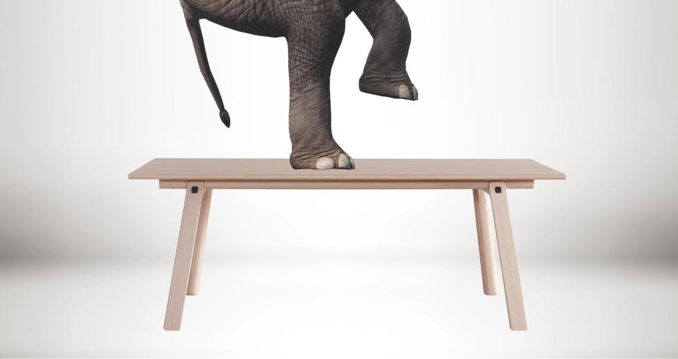 An artistic collage of an elephant standing on the T&B table, emphasizing the table's strength and stability.