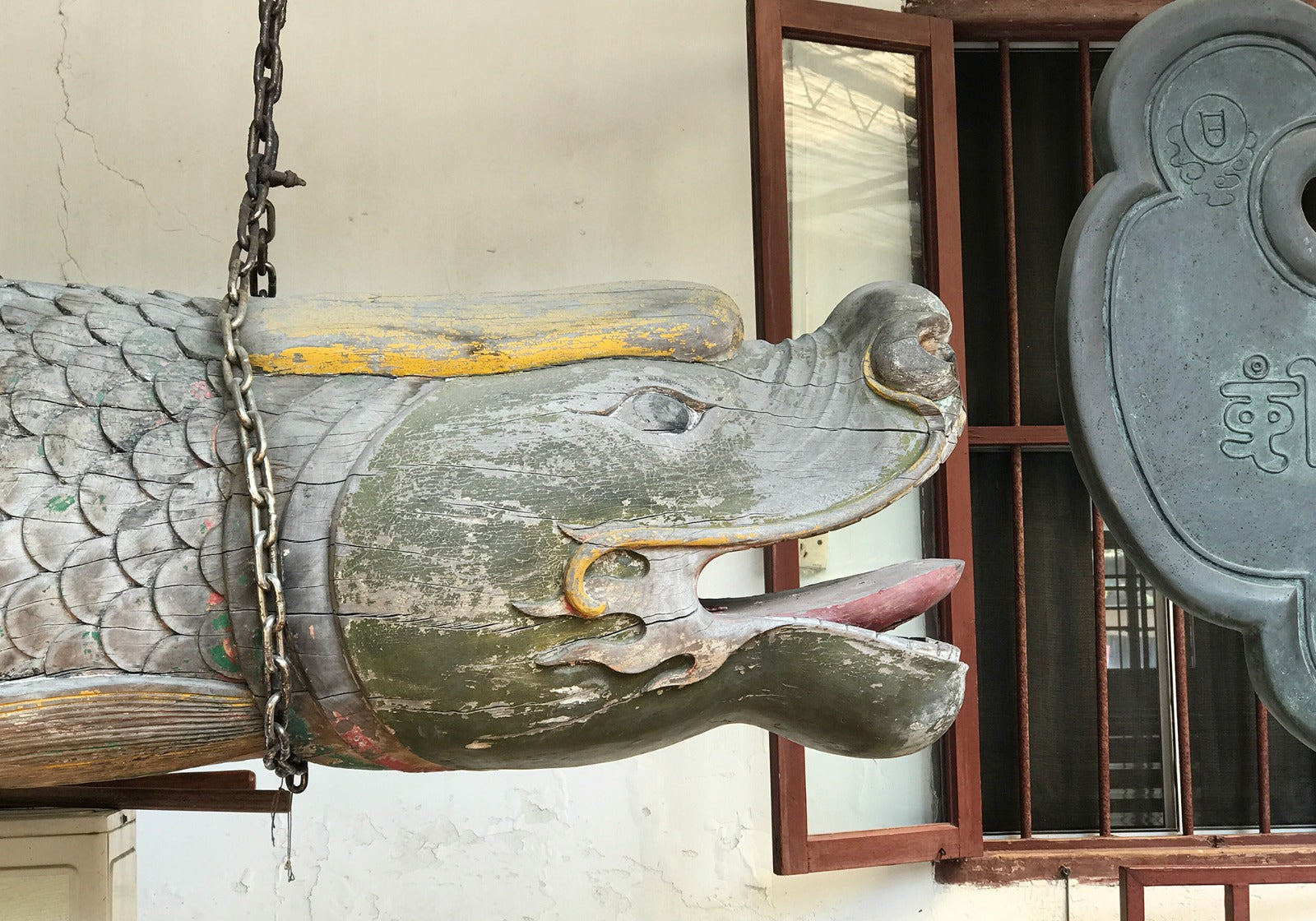 Close-up of a traditional dragon sculptured gong with intricate carvings and vibrant detailing, symbolizing cultural heritage and craftsmanship.