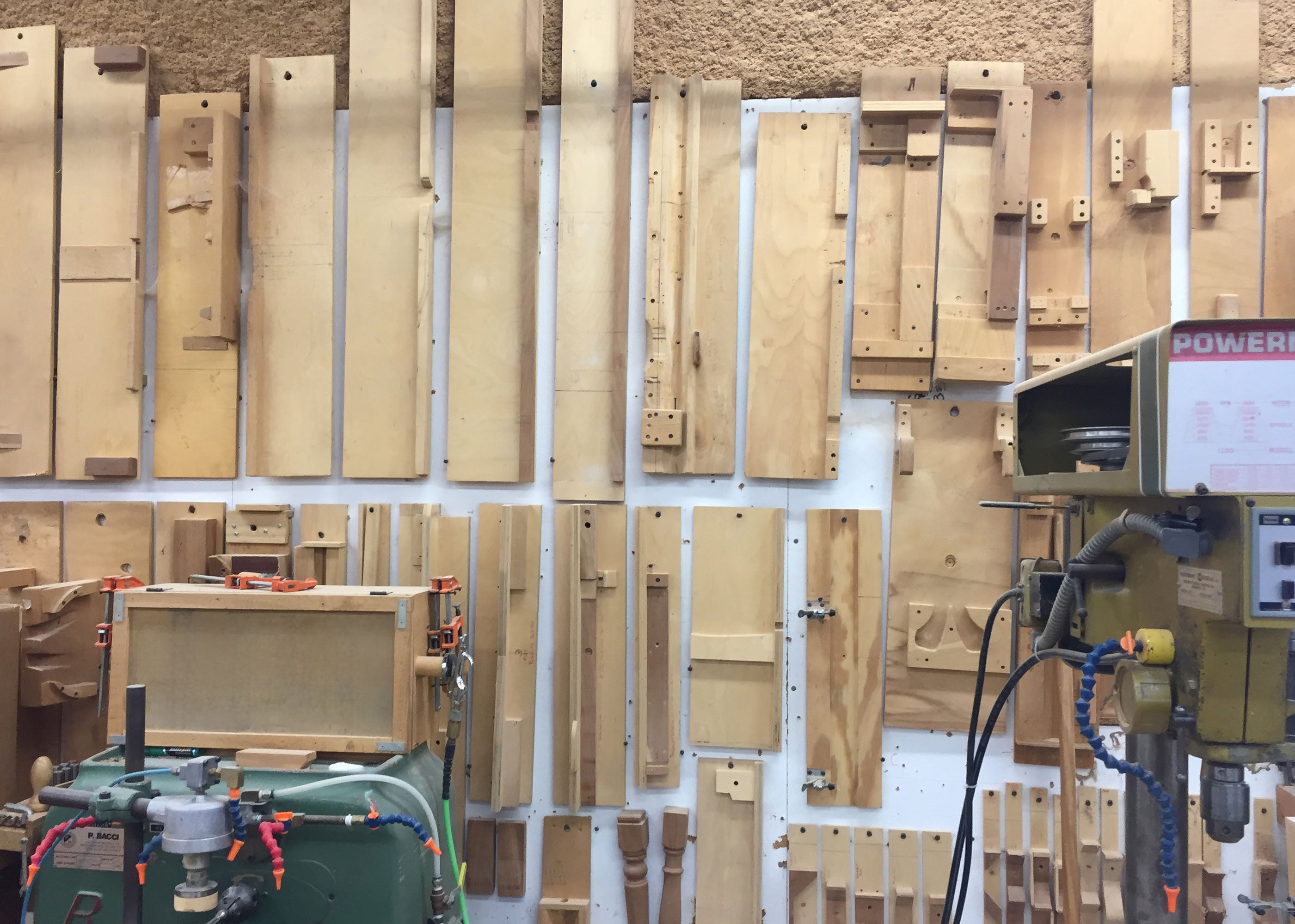Organized tools on the workbench wall inside Collect Studio's workshop.